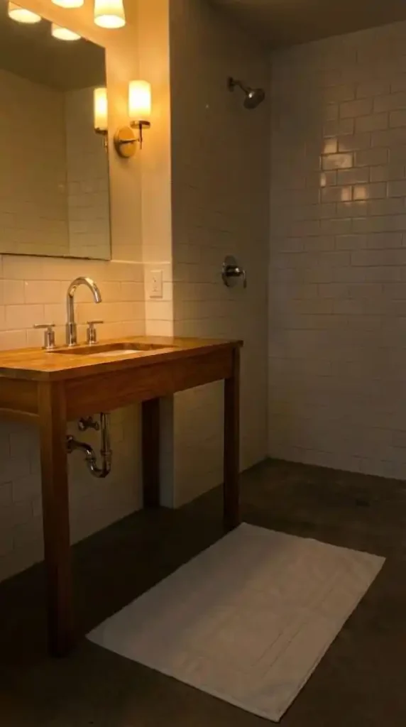 Afro Bohemian bathroom with warm 2700K sconce lighting installed on either side of the vanity mirror position