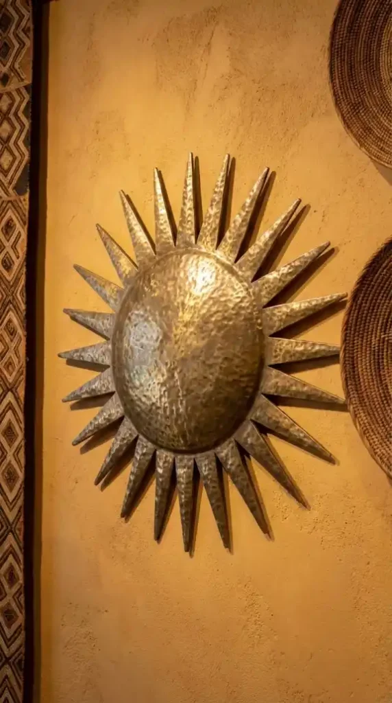Hammered-muted-brass-celestial-sun-mounted-between-gallery-elements