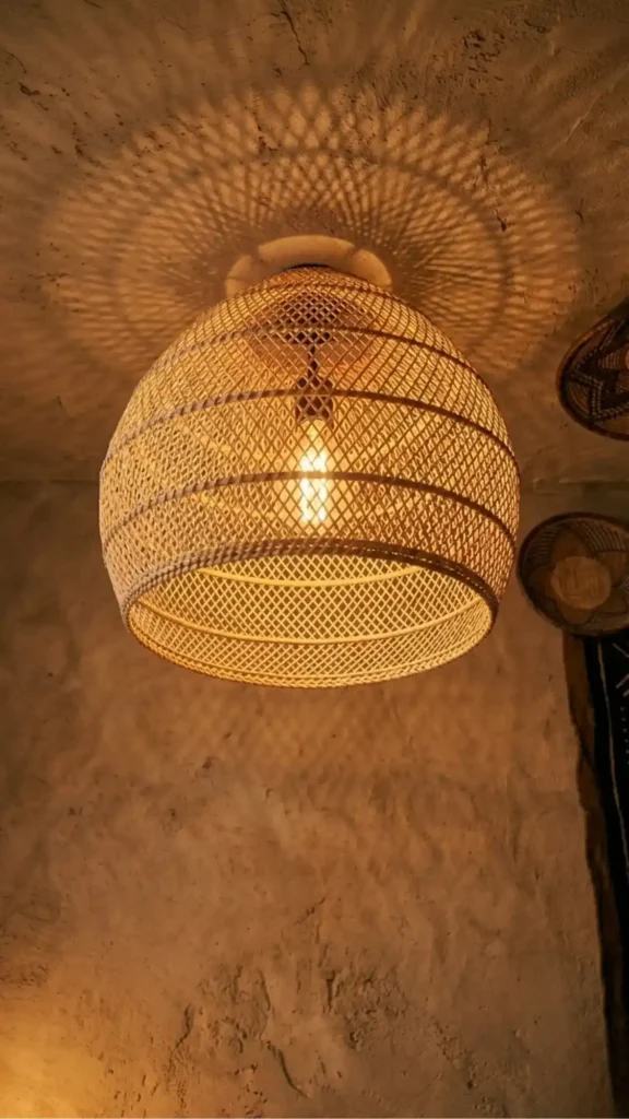 rattan-pendant-light-casting-intricate-geometric-shadow-projections-onto-a-warm-plaster-ceiling-and-wall