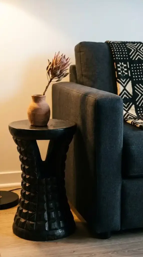 hand-carved-ashanti-stool-beside-charcoal-sofa-side-table