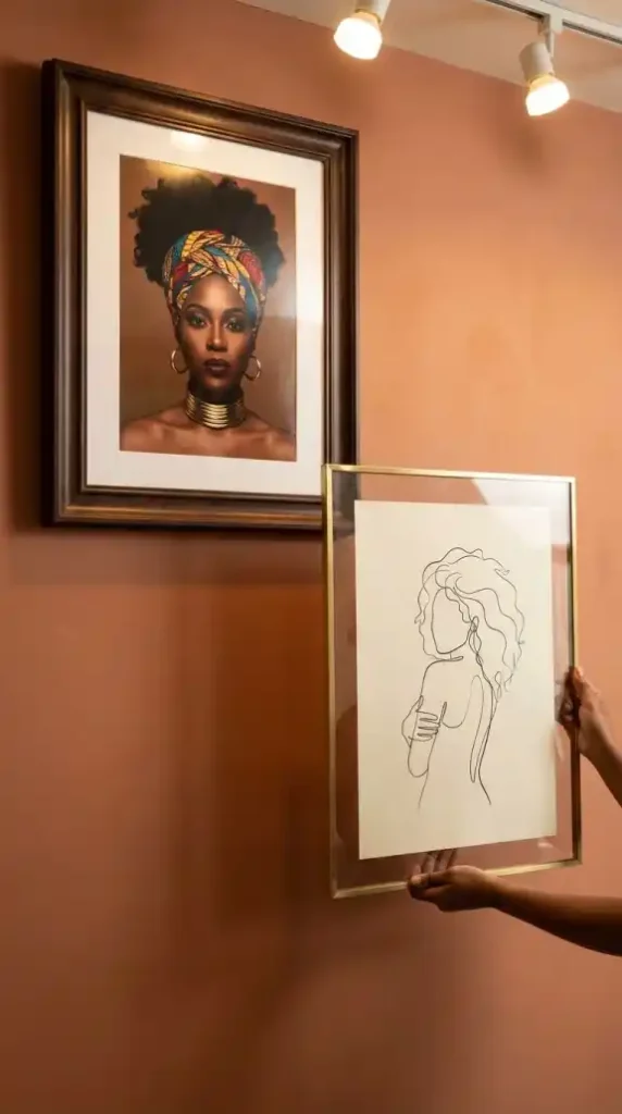 Continuous-line-art-silhouette-in-brass-frame-beside-Afro-Queen-portrait